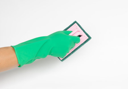 Hand with green glove cleaning with brushの写真素材