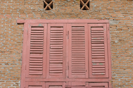 Pink wooden window with red brick backgroundの写真素材