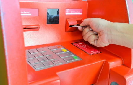 Hand inserting ATM card in ATM machineの写真素材
