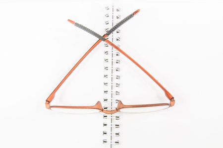 Notebook and eyeglass with isolated white 