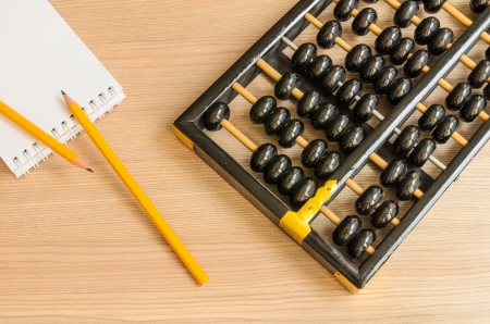 Ancient Chinese abacus,notebook,pencil on wooden backgroundの写真素材