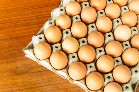 Eggs in paper tray on wooden table