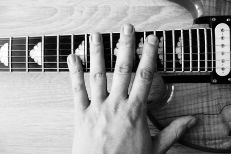 Musician`s hand on electric guitar neck. Black and white colors.の写真素材