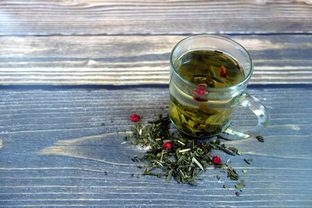 Green tea drink with red currants on wooden backgroundの写真素材