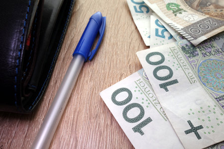 Polish paper bills, pen and purse on table, financial conceptの写真素材