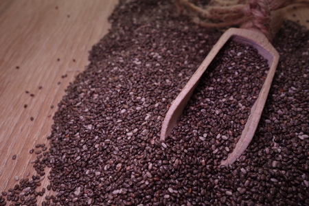Healthy chia seeds in a wooden spoon on the tableの写真素材