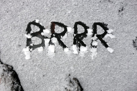 Word brrr written in snow on frozen waterの写真素材
