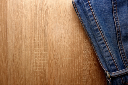 Blue denim jeans on wooden background with copy space for your designの写真素材