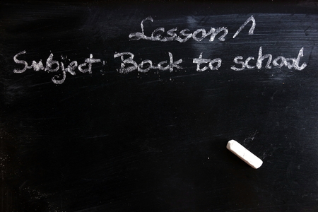 Education concept with first lesson subject - written on chalkboard, copy space for your designの写真素材