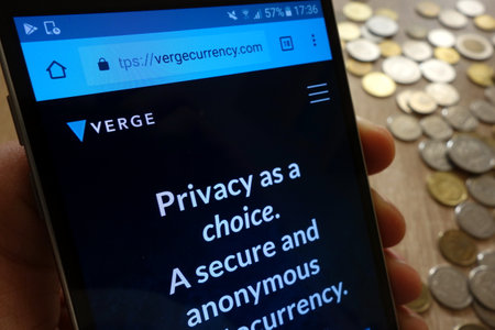 KONSKIE, POLAND - MAY 08, 2018: Verge cryptocurrency website displayed on smartphone and stack of coinsのeditorial素材