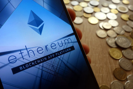 KONSKIE, POLAND - MAY 08, 2018: Ethereum cryptocurrency website displayed on smartphone and stack of...