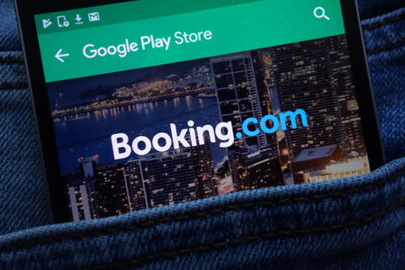 KONSKIE, POLAND - JUNE 11, 2018: Booking.com app on Google Play Store website displayed on smartphone hidden in jeans pocketのeditorial素材