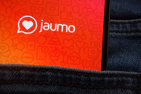 KONSKIE, POLAND - JUNE 12, 2018: Jaumo logo displayed on smartphone hidden in jeans pocketのeditorial素材