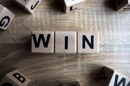 Win word from wooden blocks on deskの写真素材