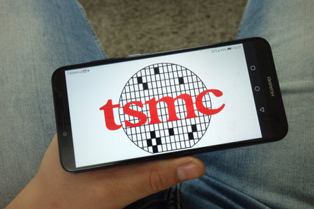 KONSKIE, POLAND - April 13, 2019: Man holding smartphone with Taiwan Semiconductor Manufacturing...