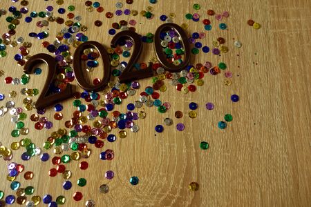 Happy New Year 2020 concept with ornamental digits and colorful shiny decorations on wooden tableの写真素材