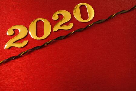 Golden number 2020 and ribbon on shiny red background, New Year celebration conceptの写真素材