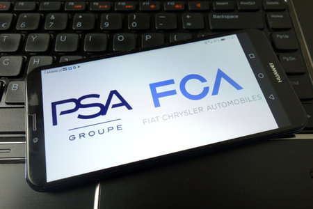KONSKIE, POLAND - December 21, 2019: PSA and FCA logos displayed on mobile phoneのeditorial素材
