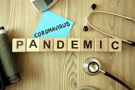 Text coronavirus pandemic with medical accessories on wooden background, healthcare conceptの写真素材