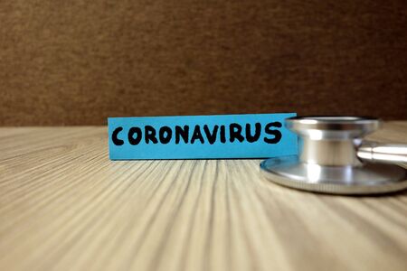 Word coronavirus on sticky note with stethoscope, healthcare and medical conceptの写真素材
