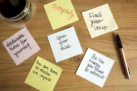Inspirational and motivational slogans handwritten on sticky notes with pen and coffee, self development conceptの写真素材