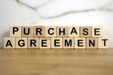 Purchase agreement text from wooden blocks, financial conceptの写真素材