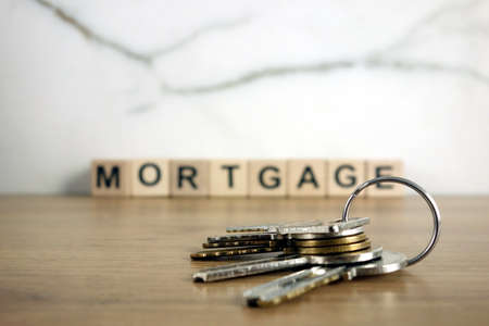 House keys with word mortgage from wooden blocks, property purchase investment and financial real estate conceptの写真素材