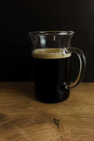 Black espresso coffee in glass cup on wooden tableの写真素材