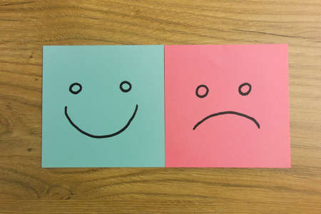 Happy and sad face emoticons. Change of mood, relationship difficulties, depression conceptの写真素材