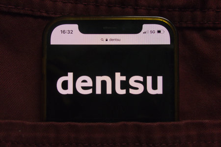 KONSKIE, POLAND - February 22, 2022: Dentsu Group Inc logo displayed on mobile phone hidden in jeans...