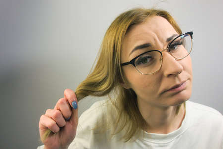 Young woman holding her blond hair. Copy space for your designの写真素材