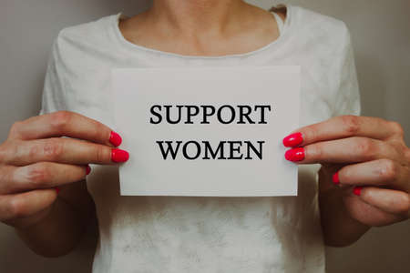 Woman holding sheet of paper with text support women. Break the bias, solidarity, gender equality and breaking stereotypes, international women`s day conceptの写真素材