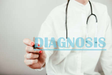 Female doctor writing word diagnosis. Health care and medical conceptの写真素材