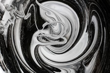 abstract image mixing of two colors. The texture of the circles of white and black paintの写真素材