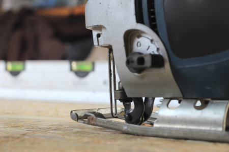 blue-silver electric jigsaw on the osb plate. The process of sawing OSB plywood