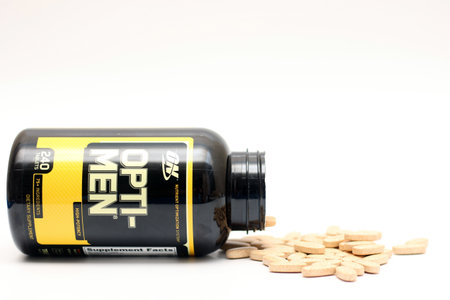 Kiev, Ukraine - December 15th, 2020: Open jar of multivitamin complex optimen from which pills scatteredのeditorial素材