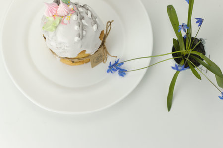 Orthodox Easter cake with white fondant and marshmallows tied with a rope with a tag on a plate with...