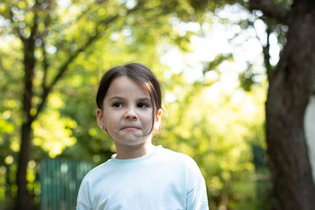 Close-up portrait of little beautiful biracial girl on blurred rural background with lovely bokeh