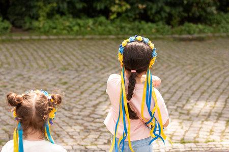 Little redhead preschooler girl with pigtails in national ukrainian folk decoration wreath outdoorsの写真素材
