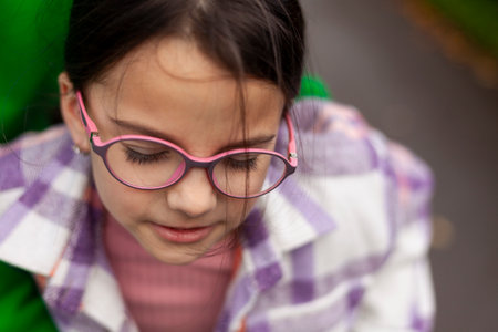 Portrait of a cute little girl wearing glasses and a plaidの写真素材