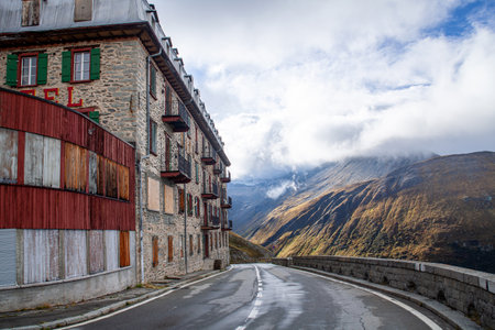 Mountain road in the Swiss Alps with old houses in the foregroundの写真素材