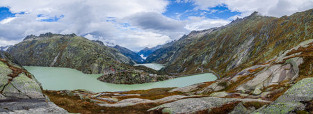 Panoramic photo of a desert road among milky green lakes in the Swiss Alps in autumn. Beautiful...