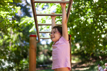 Little girl playing on the playground in the park on a sunny day