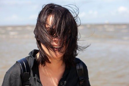 portrait of a young girl with black hair on the beach.