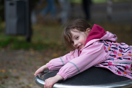 Little girl on a swing in autumn park. Selective focus.