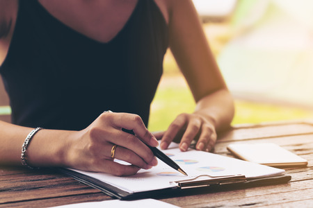 Businesswoman checking paper, chart or business report on a working desk. Business plan and report analysis.の写真素材