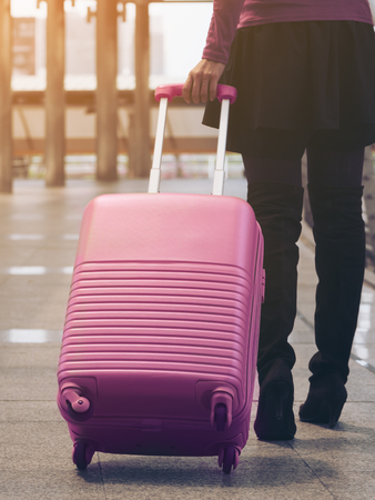 Woman traveller walking in airport walkway with travel bag or luggage. Traveler travel abroad through international airport terminal. Concept of woman travel, traveling lifestyle with travel bag.の写真素材
