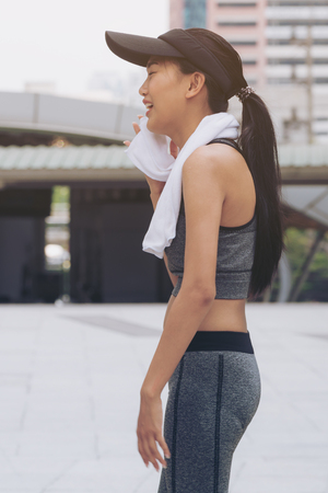 Healthy woman running in the city background in morning running exercise wearing runner sportswear. Concept of women fitness health, run exercise, healthy lifestyle.の写真素材
