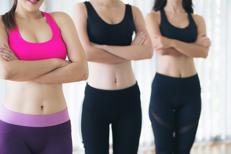 Sporty women team standing in fitness gym, cross arms with confidence. Healthy lifestyle and wellness concept.の写真素材