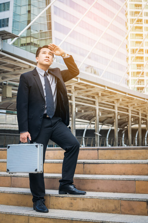 Business man looking away in the modern city view, anticipating business future. Concept of CEO leader, leadership and business visions.の写真素材
